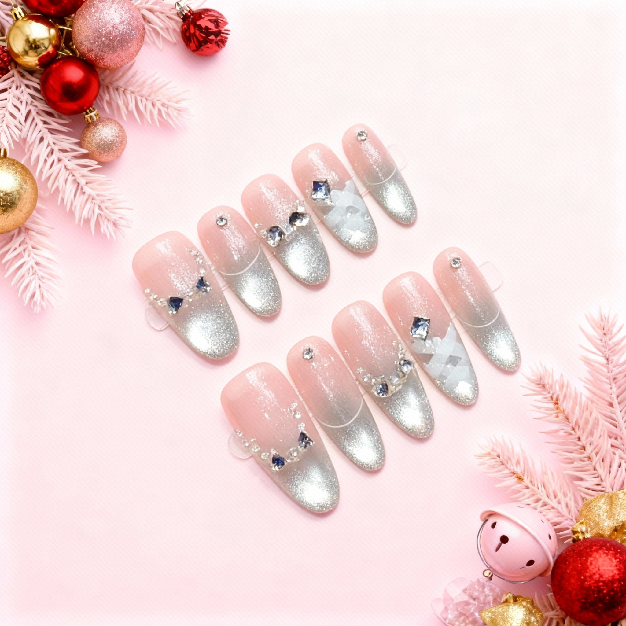 Christmas Ballet silver cat-eye French press-on nails with soft pink base, glittered silver tips and crystal bow accents on pink holiday background