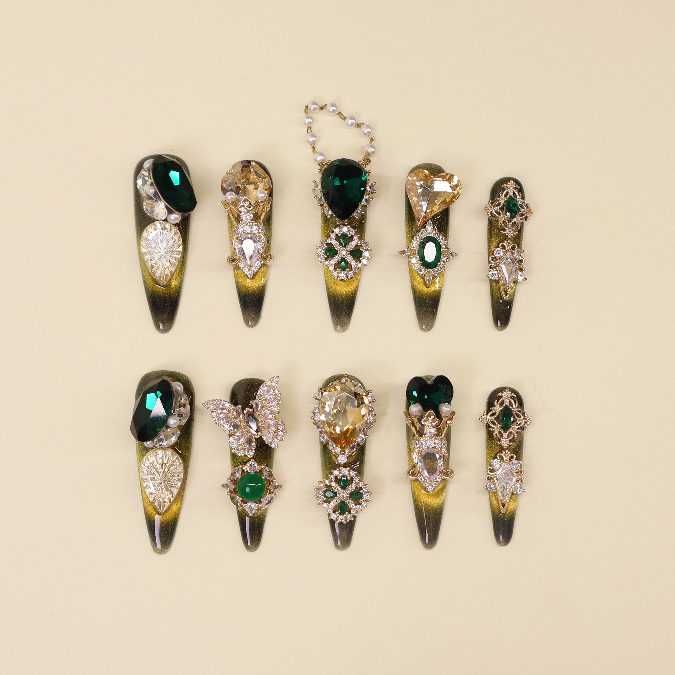 Luxury emerald press on nails with deep green base, gold accents, and statement crystal details