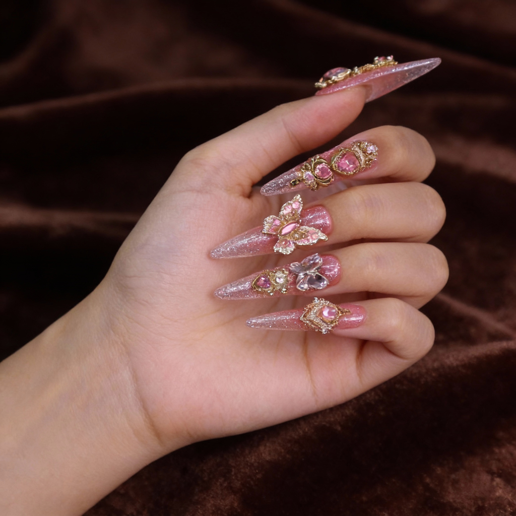 Close-up of romantic pink luxury press on nails featuring heart-shaped crystals, butterfly accents, and fine shimmer finish