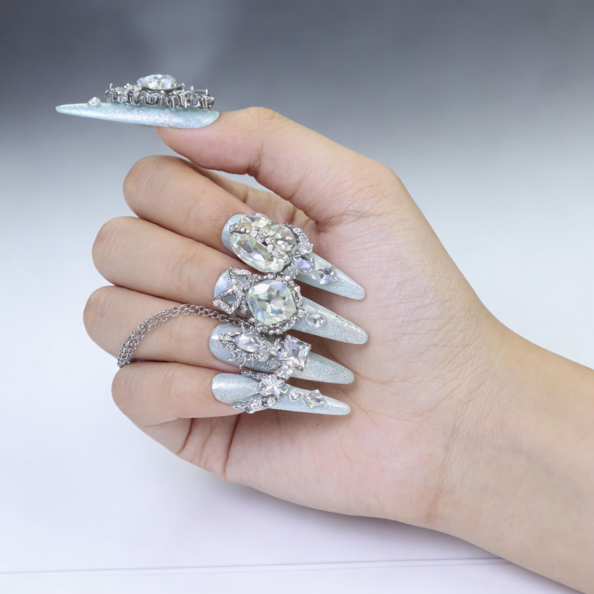 Close-up of mint green icy nails with subtle sparkle and smooth glossy texture