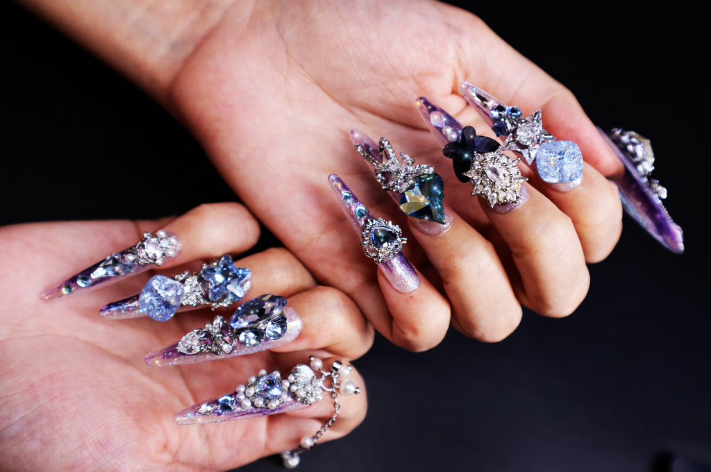 Elegant purple press-on nails with 3D butterfly charms and sparkling crystal nail art, designed for formal and evening wear.