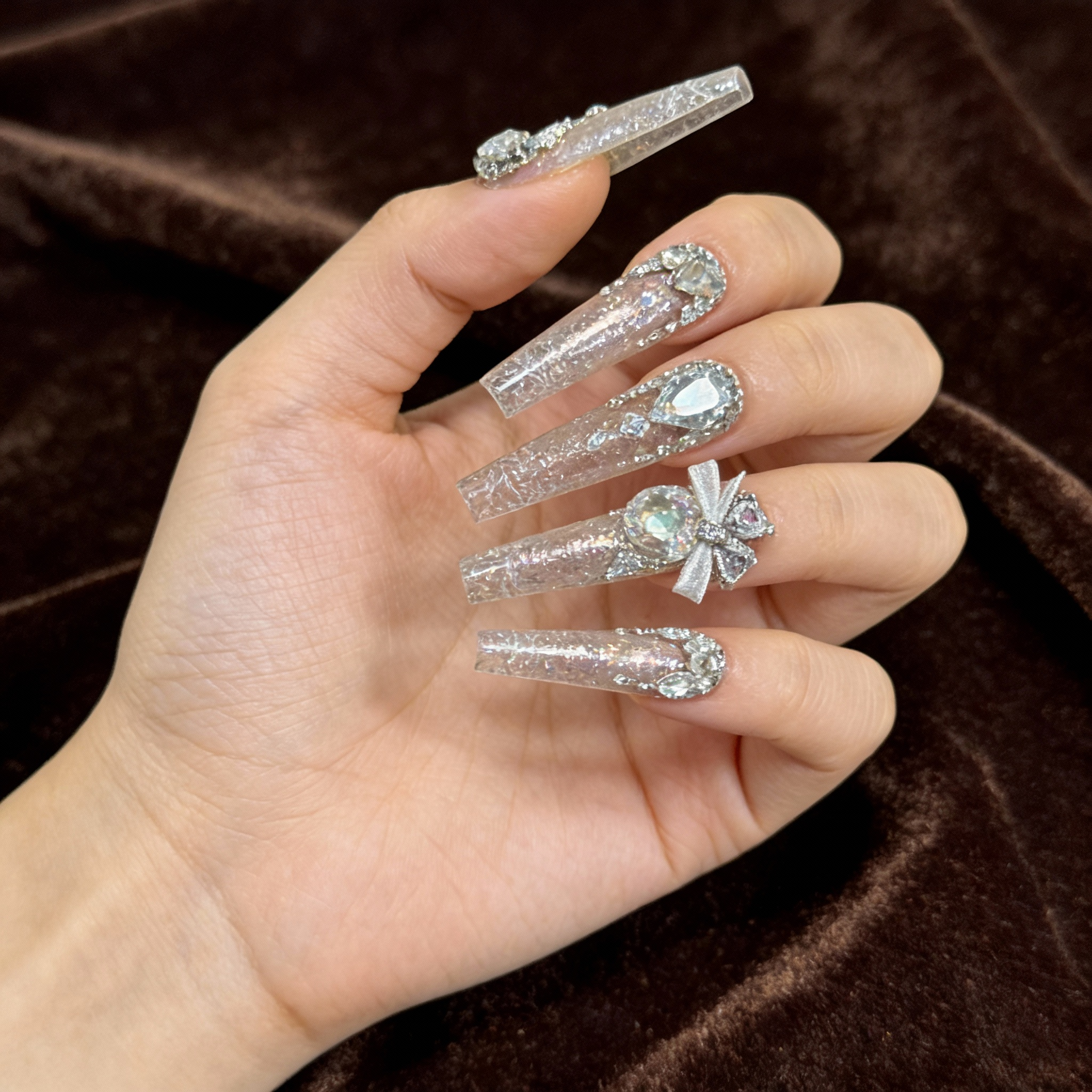 Model wearing Glacier Sparkle sparkly winter nails under natural light, highlighting intense shimmer and ice crystal transparency.
