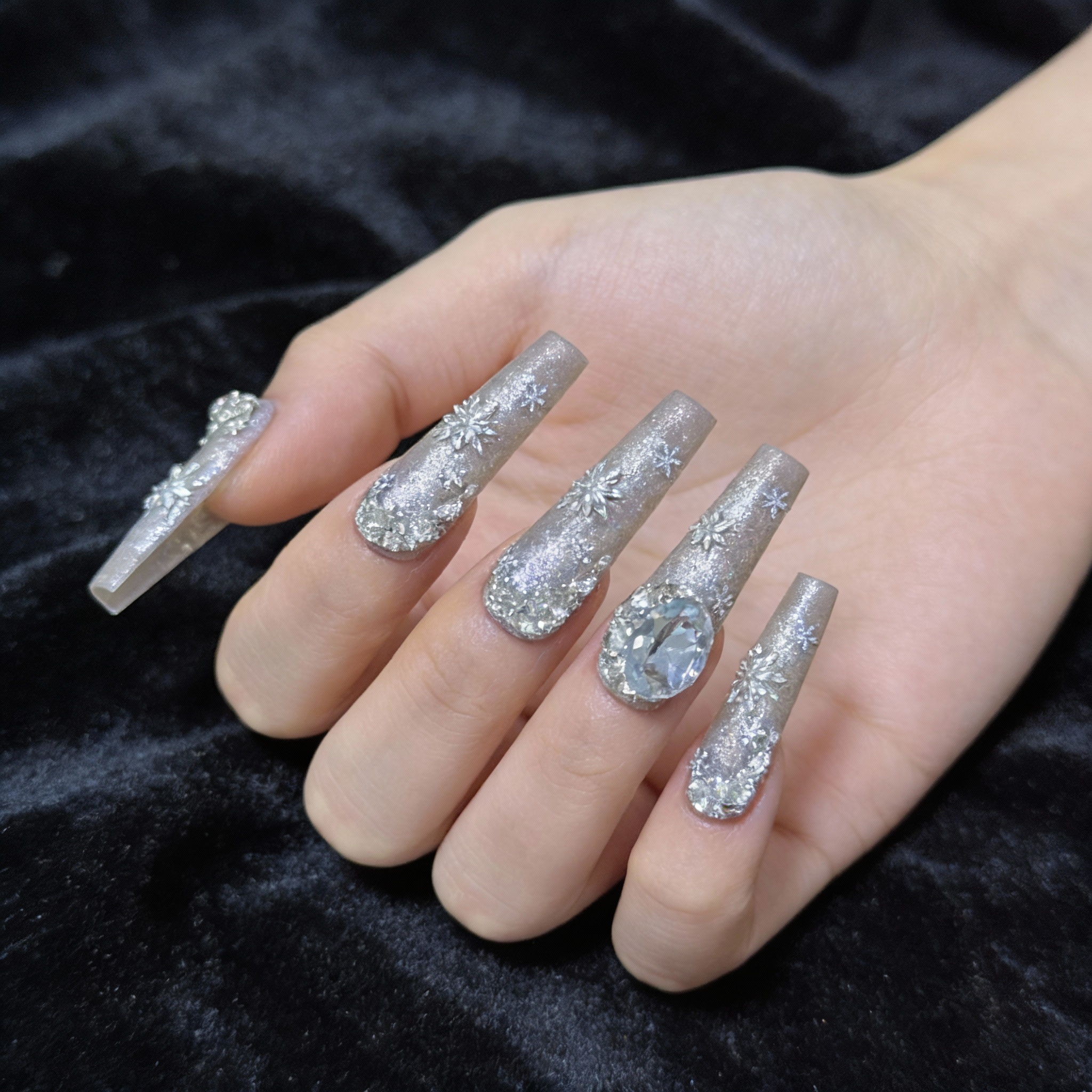 Hand model wearing Snowfall Day winter nails with cool silver glow and clean glass-like texture