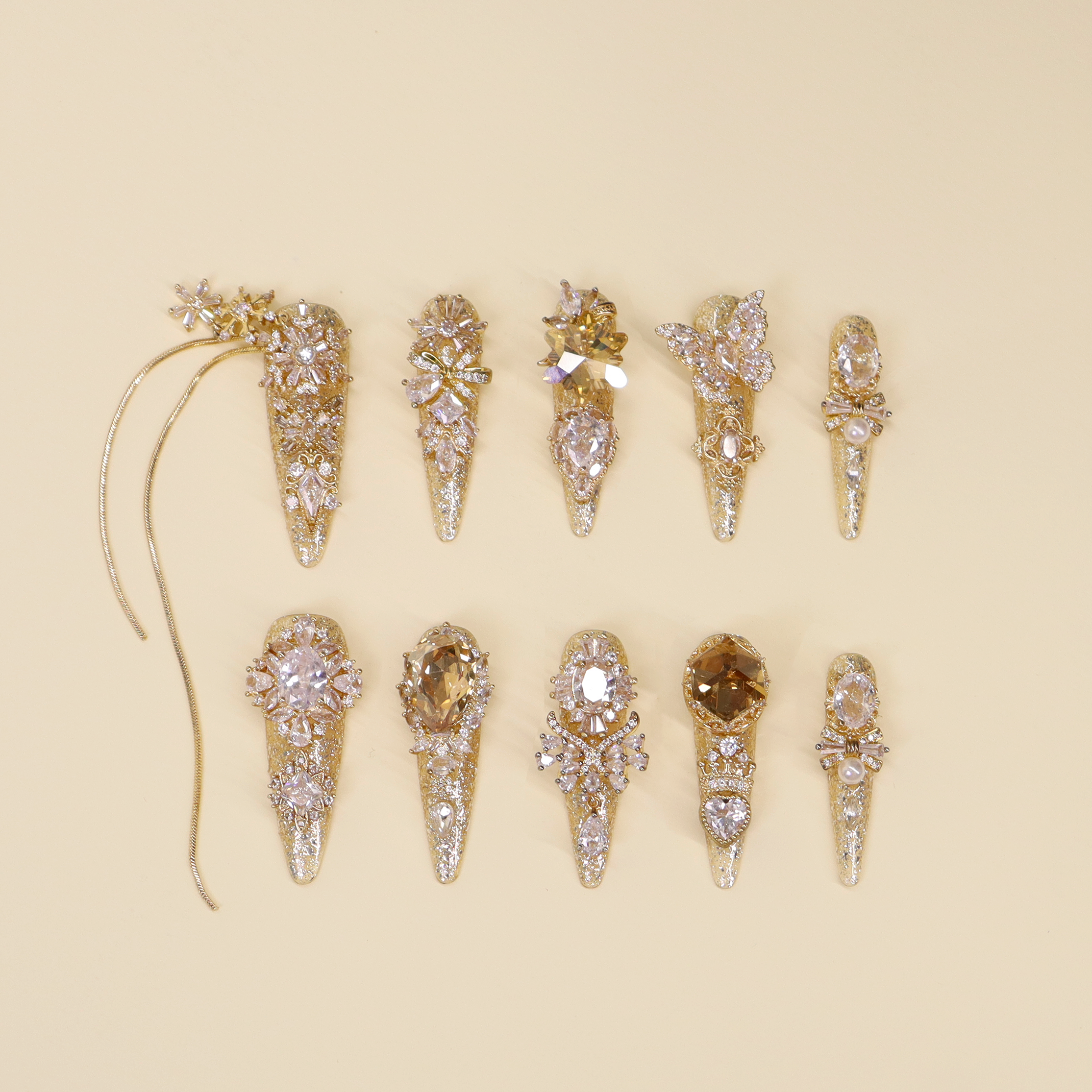 Luxury gold press on nails with fine glitter, sculptural crystal details and pearl accents, elegant statement nail design inspired by fine jewelry