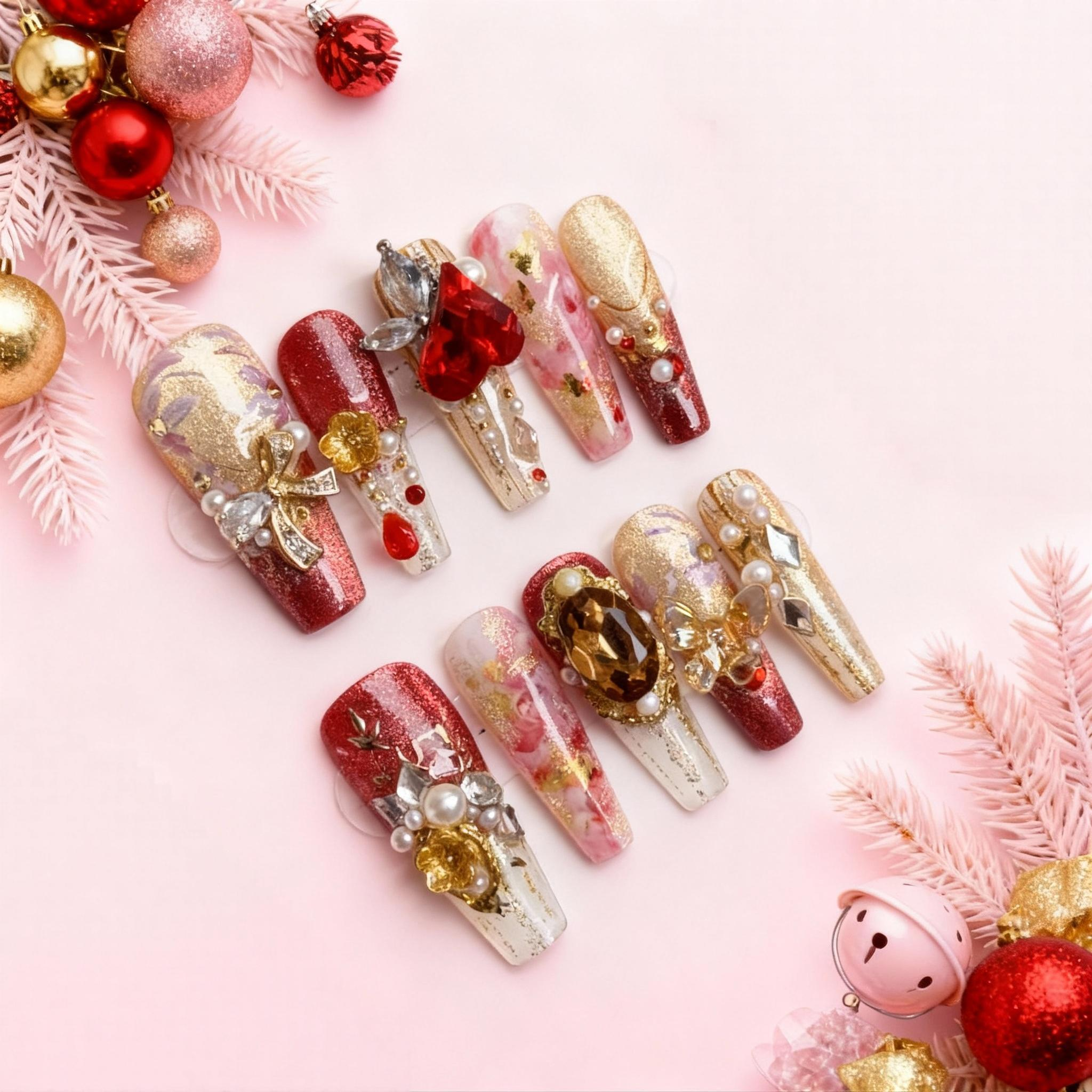 Luxury red and gold Christmas press on nails with large ruby heart gemstone, amber crystal, pearls and baroque hand-painted detailing on a pink background.