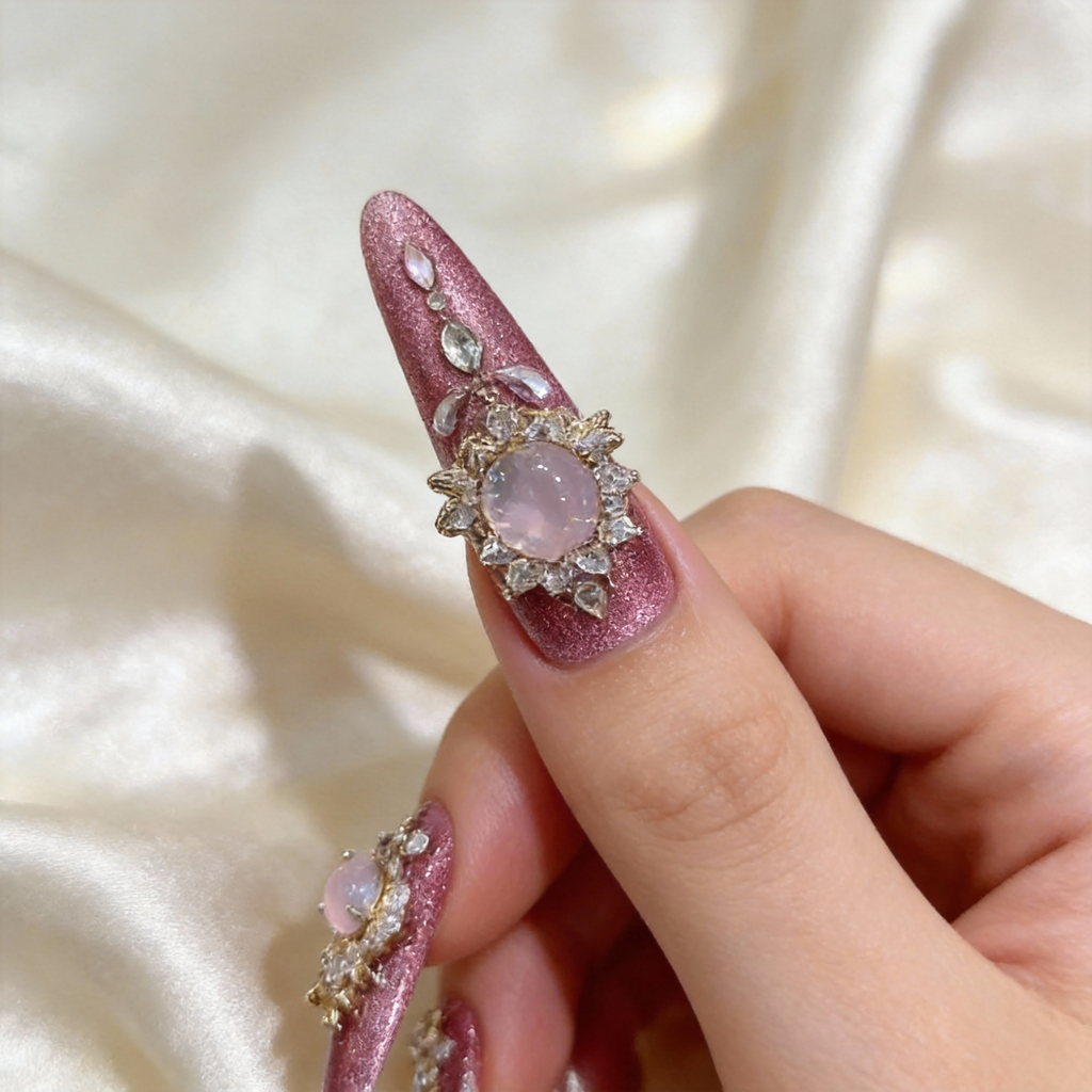 Close-up of rose shimmer press-on nails with gold-toned details