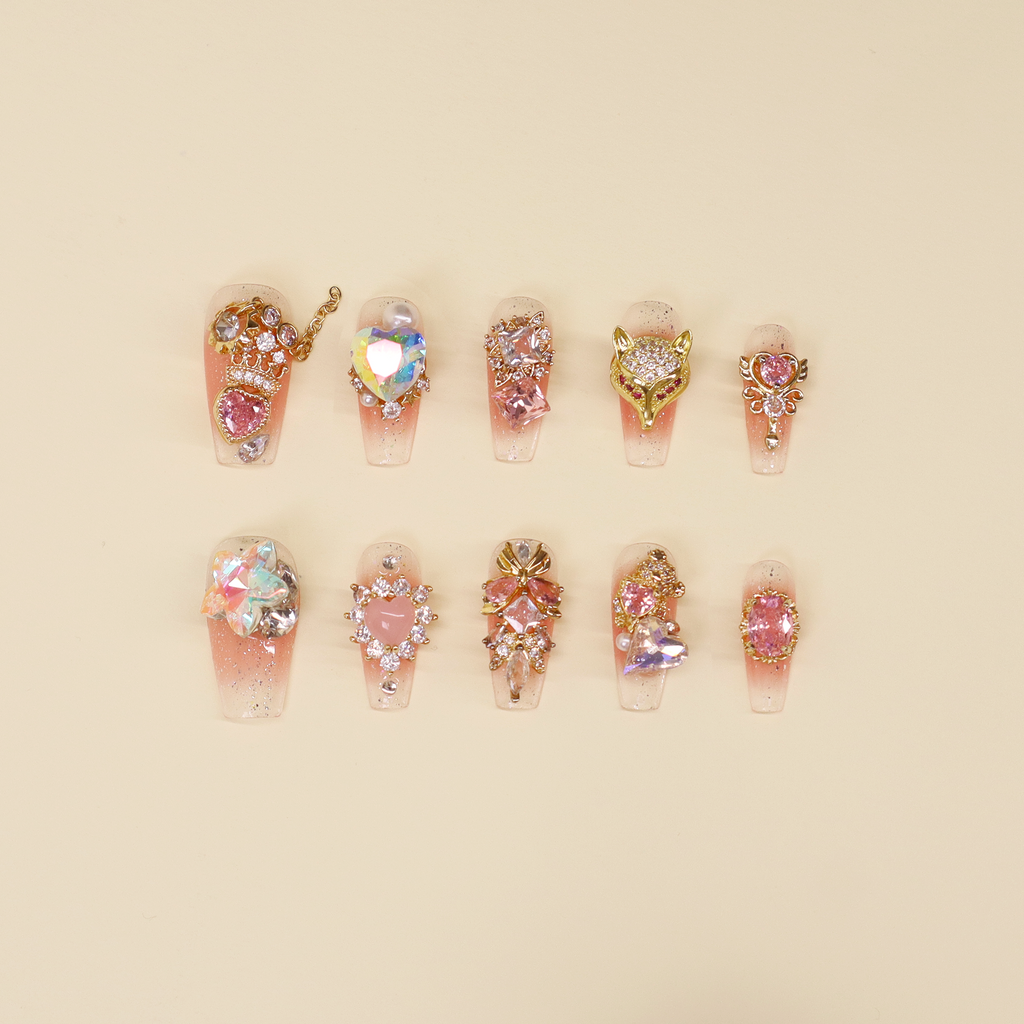 Luxury short press on nails featuring gold fox head charm, emerald green stones, pearls, and sculptural metallic detailing on a deep polished base