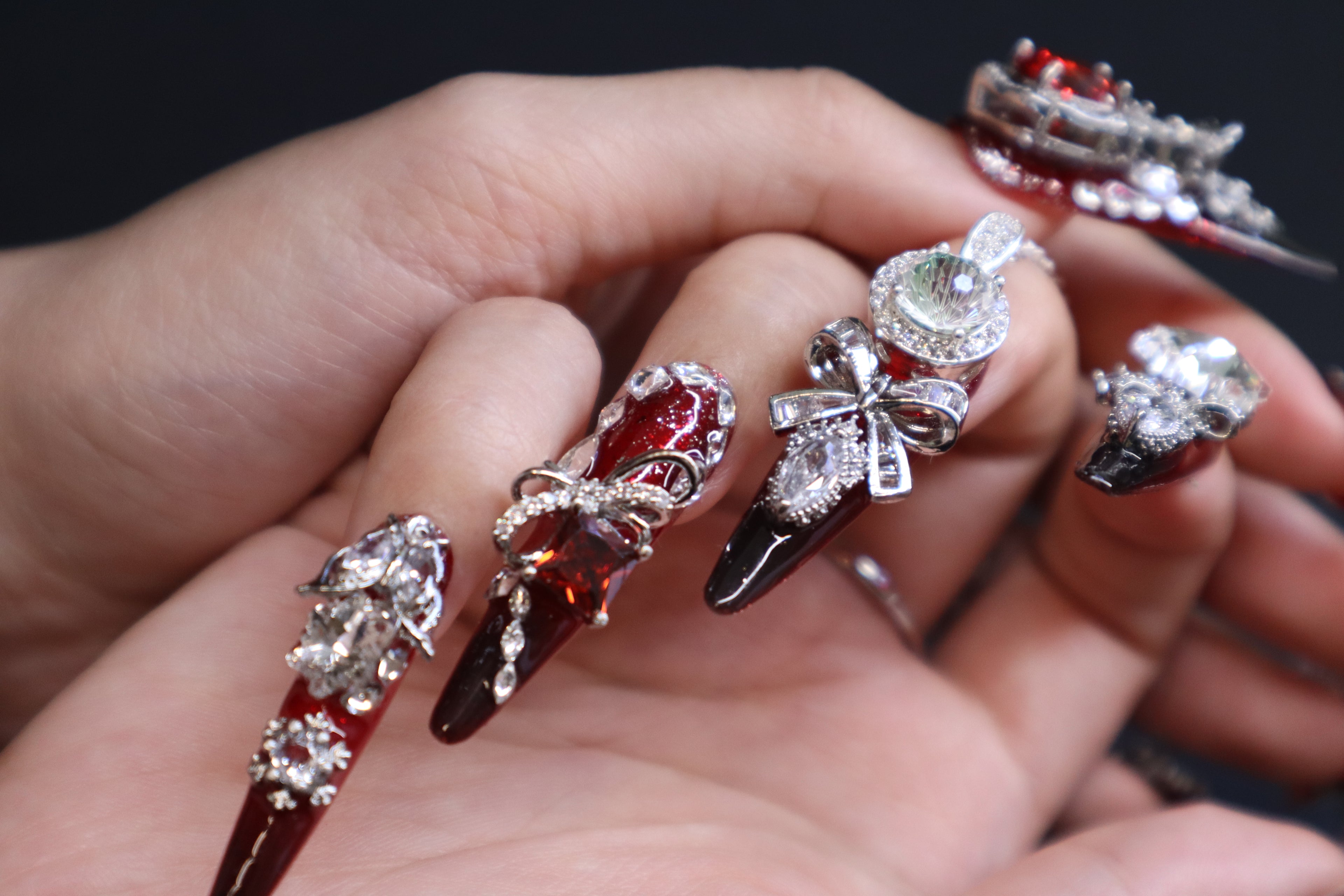 Red and black gradient press-on nails featuring premium crystal accents and gothic luxury nail art